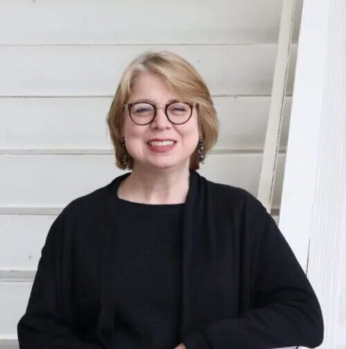 Caucasian lady with Blond colored hair in black top 