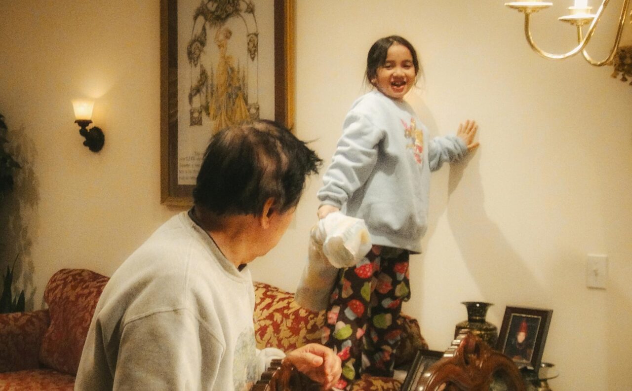 a young child with her grandfather in a living room