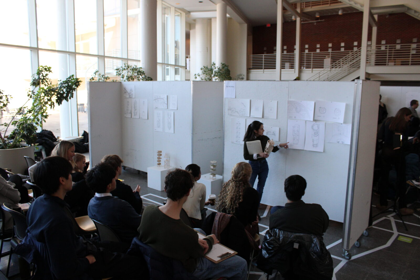 Student presenting their work to reviewers and students