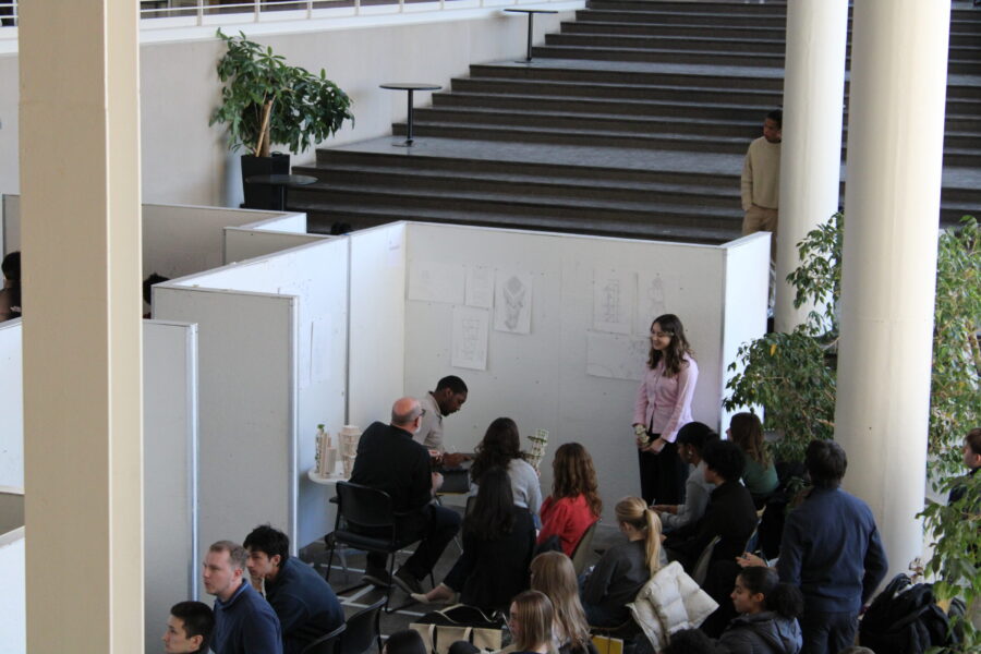 Student presenting their work to reviewers and a few students