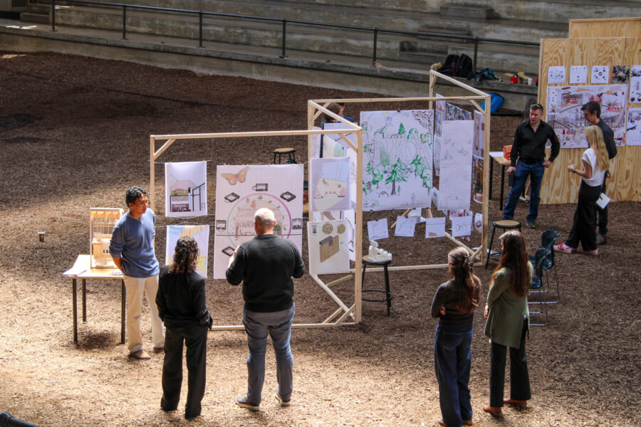 Students and professors looking at work in the stock pavilion 