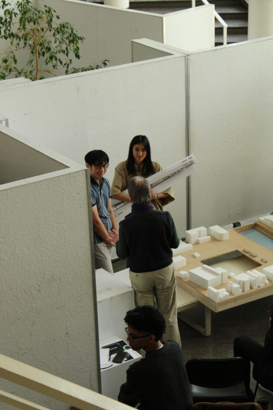 Two students talking to a professor