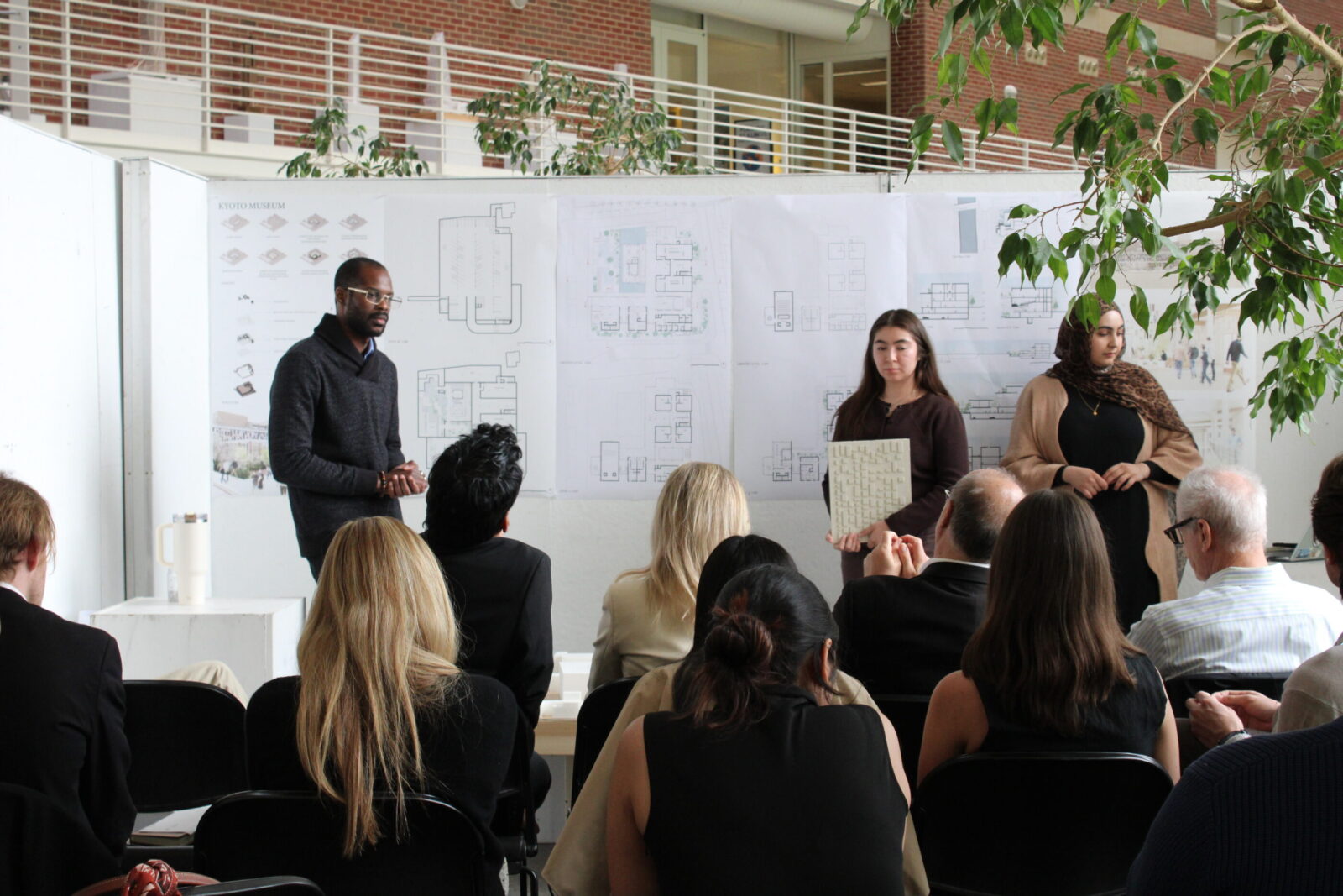 three students presenting their work