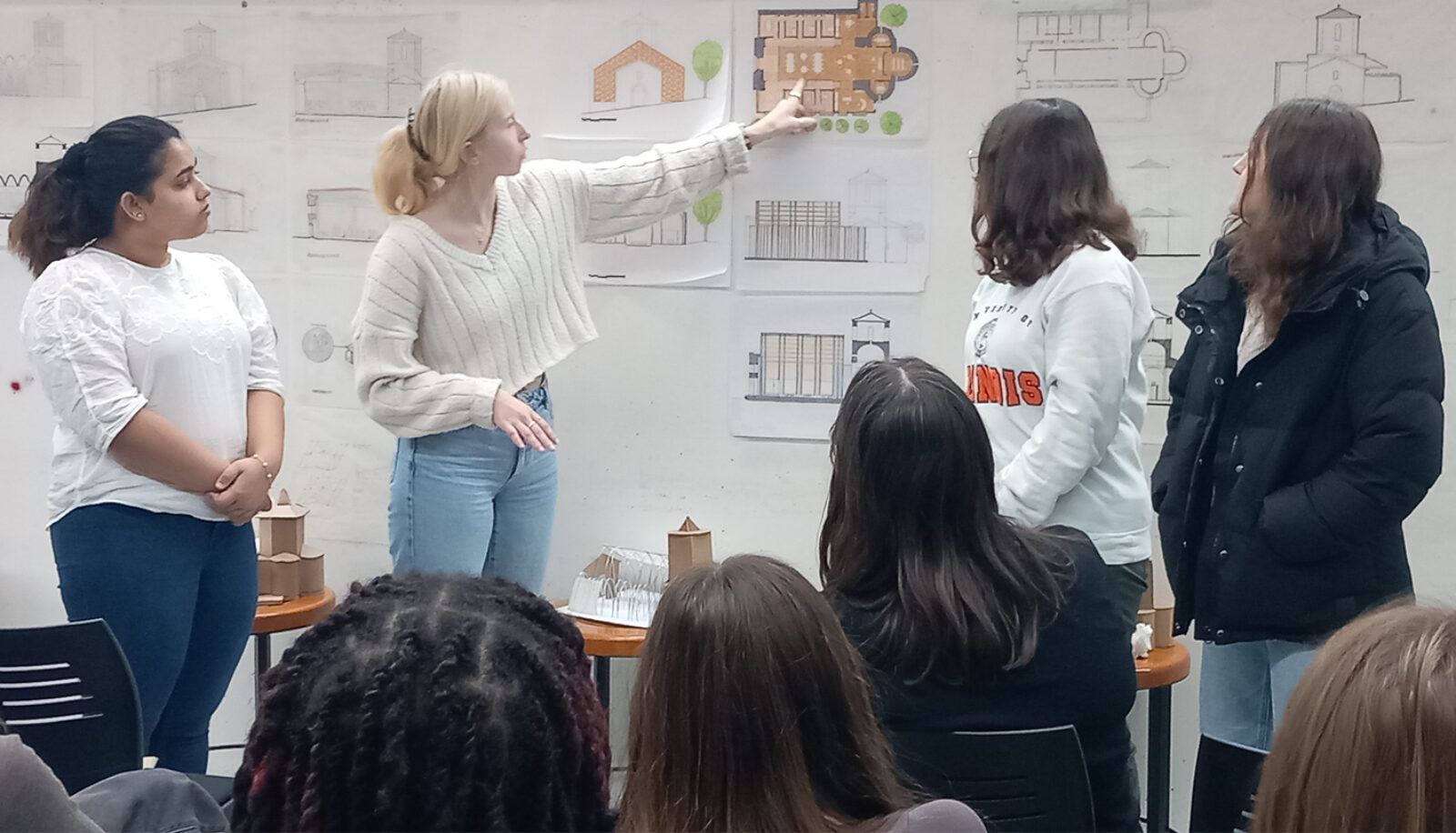 students pointing to drawings