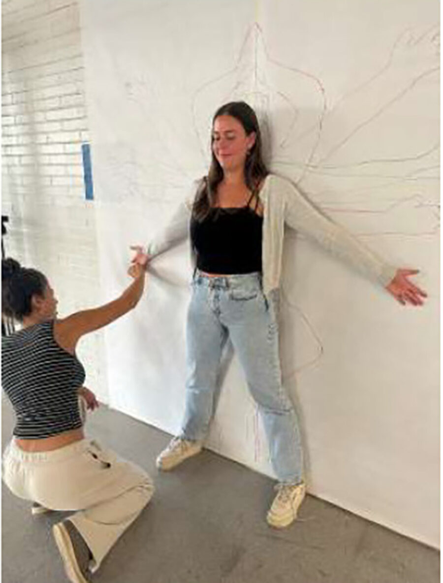 tracing student against wall