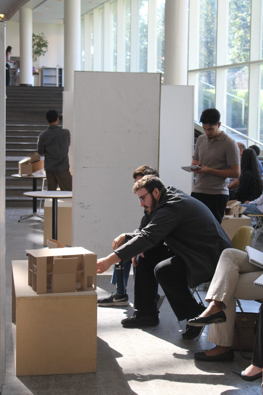 reviewer looking at student's physical model 