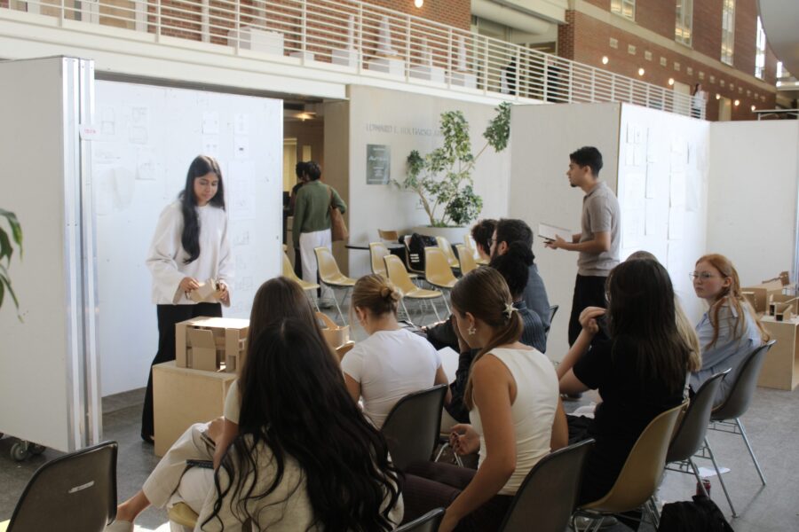 student presents work to fellow students and reviewers