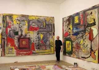 Tom Goldenberg with two paintings in his studio