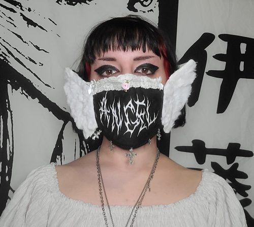 Woman wearing a black mask with a white pattern and white wings  