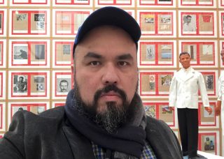 Jorge Lucero in front of art exhibit