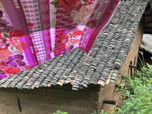 Pink linen hanging outdoors above a rustic rooftoop