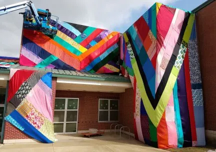 Photo of color fabric installation by surrounding the entrance of an elementary school.