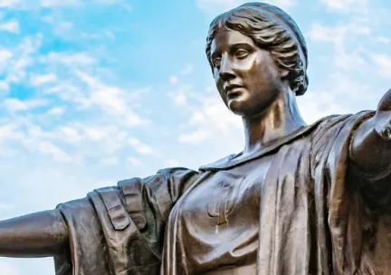 Closeup photo of Alma Mater statue with upraised arms