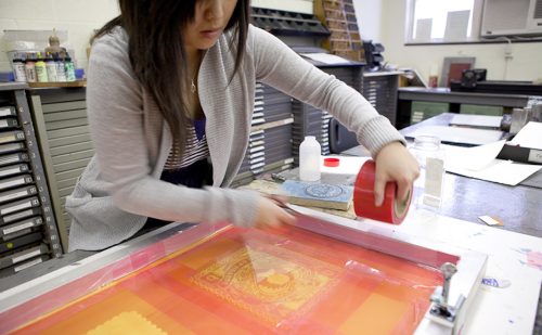 Photo of a student making a silkscreen print