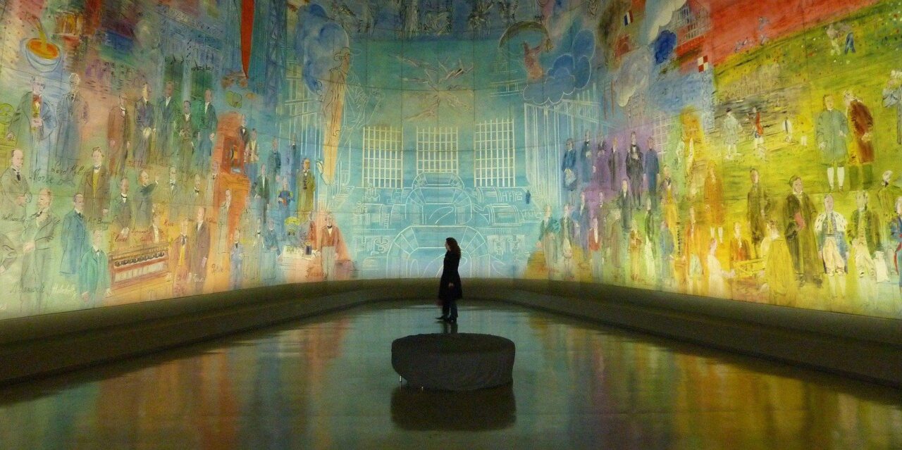 Photo of museum visitor standing in a large curved mural installation