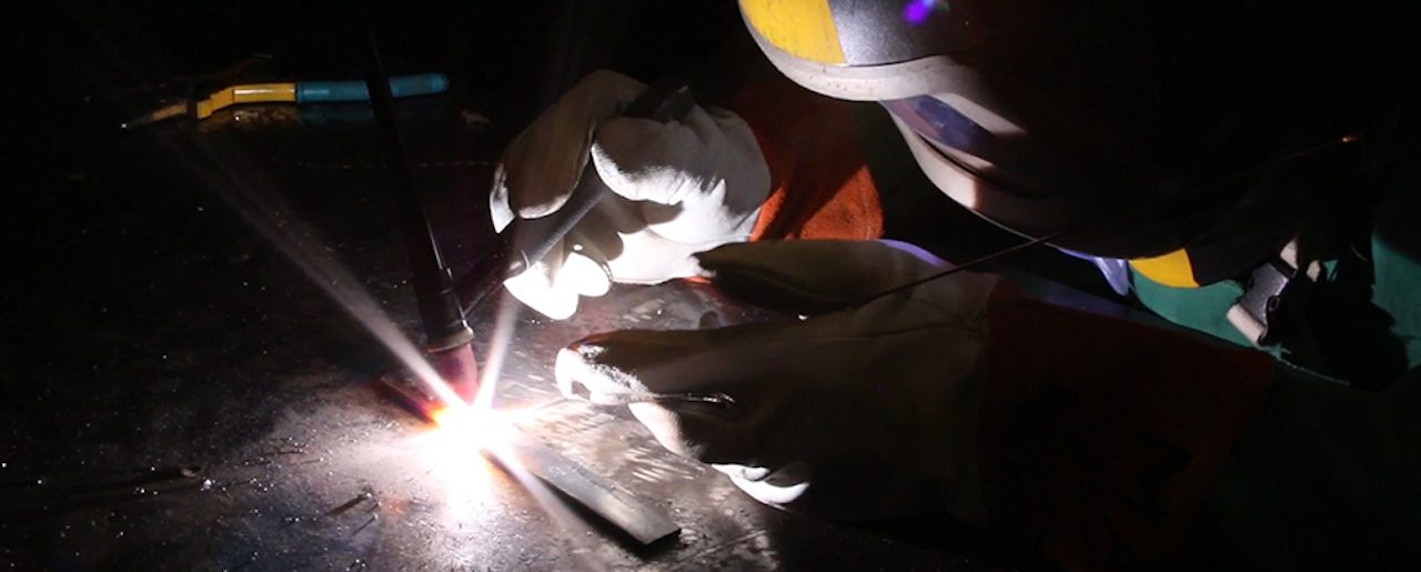 person welding wearing a welding mask