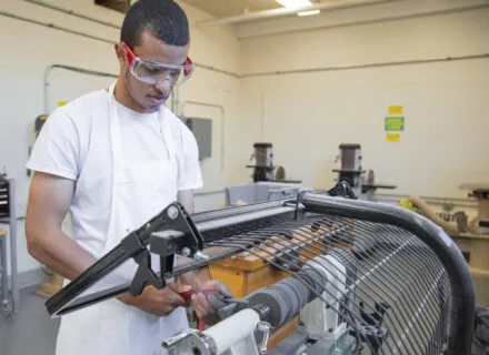 student using a lathe in the woodshop