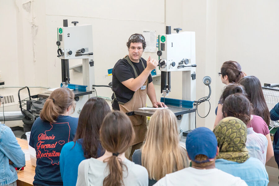 person showing students how to use a bandsaw