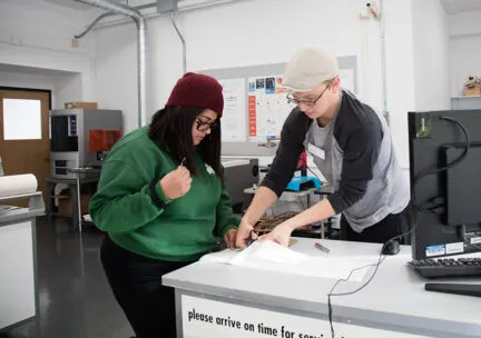 lab assistant helps student with weeding cut vinyl