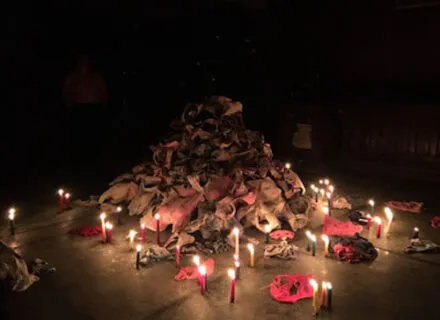 Photo of a pile of undergarments in a dark space lit by candles