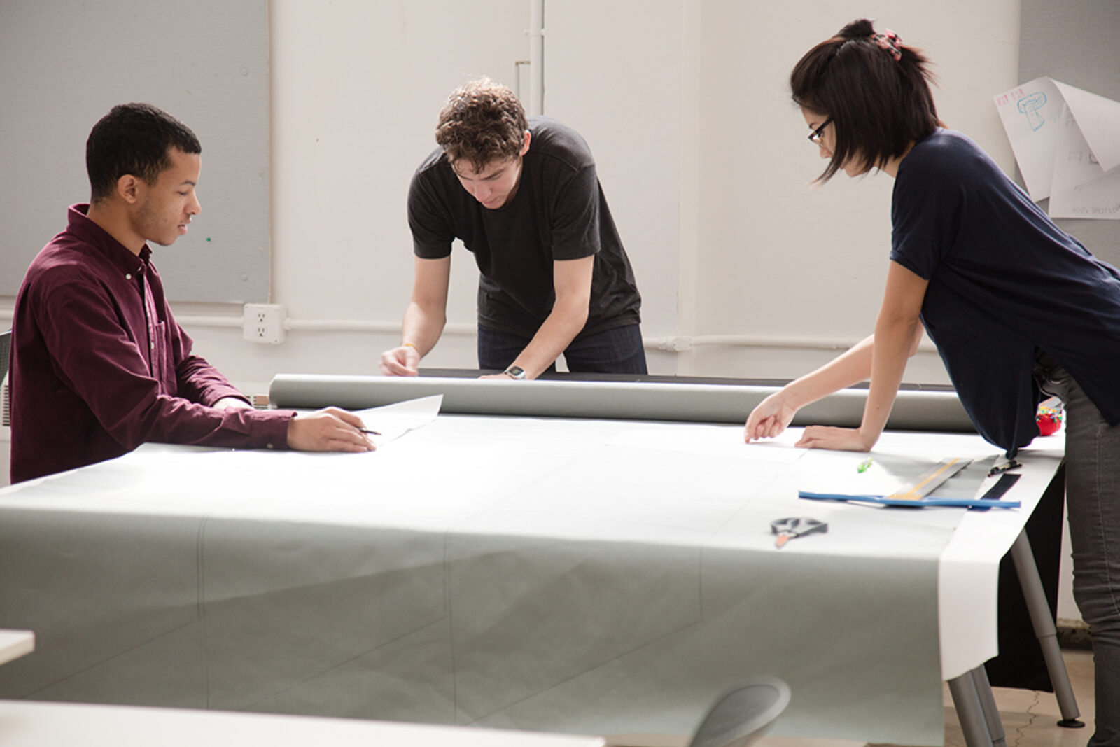 three students work around a large table