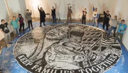 students around large medallion painted on floor