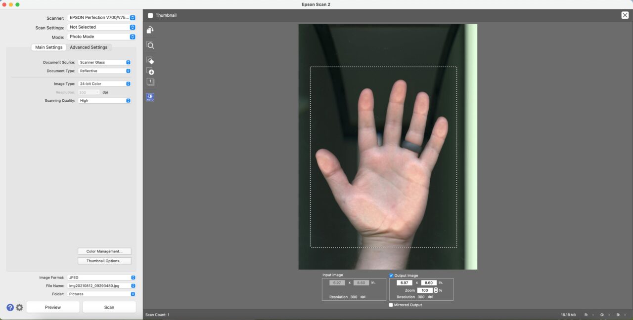 scanning software interface with preview image of a hand on the scanner