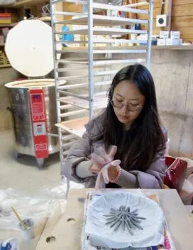 PhD student making a ceramic sculpture with their hands