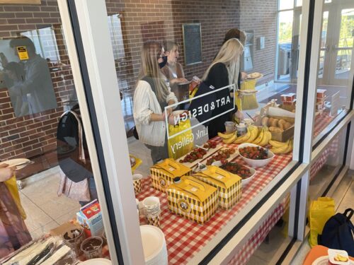 students behind glass eating snacks