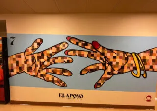 Graffiti mural of two hands reaching for each other