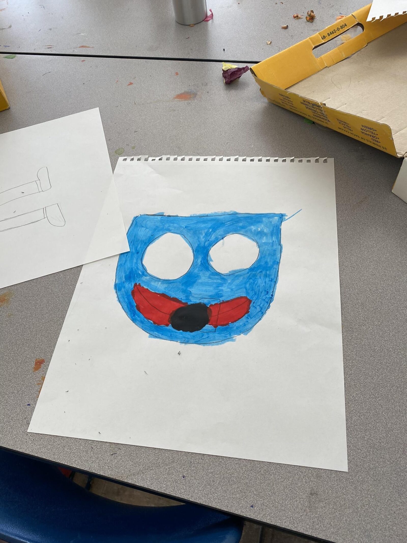 a student's drawing of a mask in blue and red