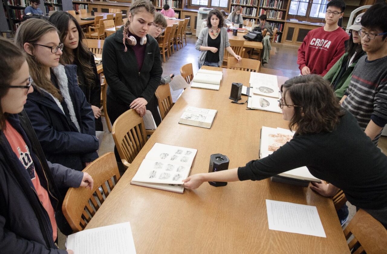 students looking at illustrated books in Ricker Library