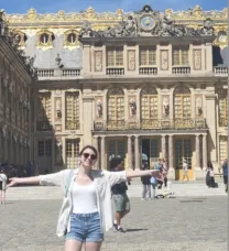 woman standing with arms stretch out in front of a building