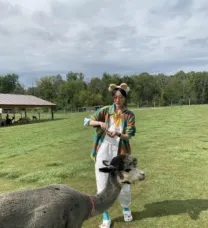 Young woman feeding a llama