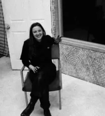 Picture of Emily Tomlinson sitting in a chair, in black and white.