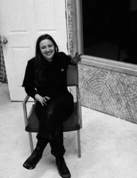 Picture of Emily Tomlinson sitting in a chair, in black and white.