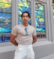 image of young man in front of stained glass window