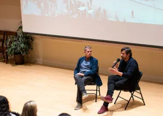 font bas and bianchi sitting on chairs on a stage