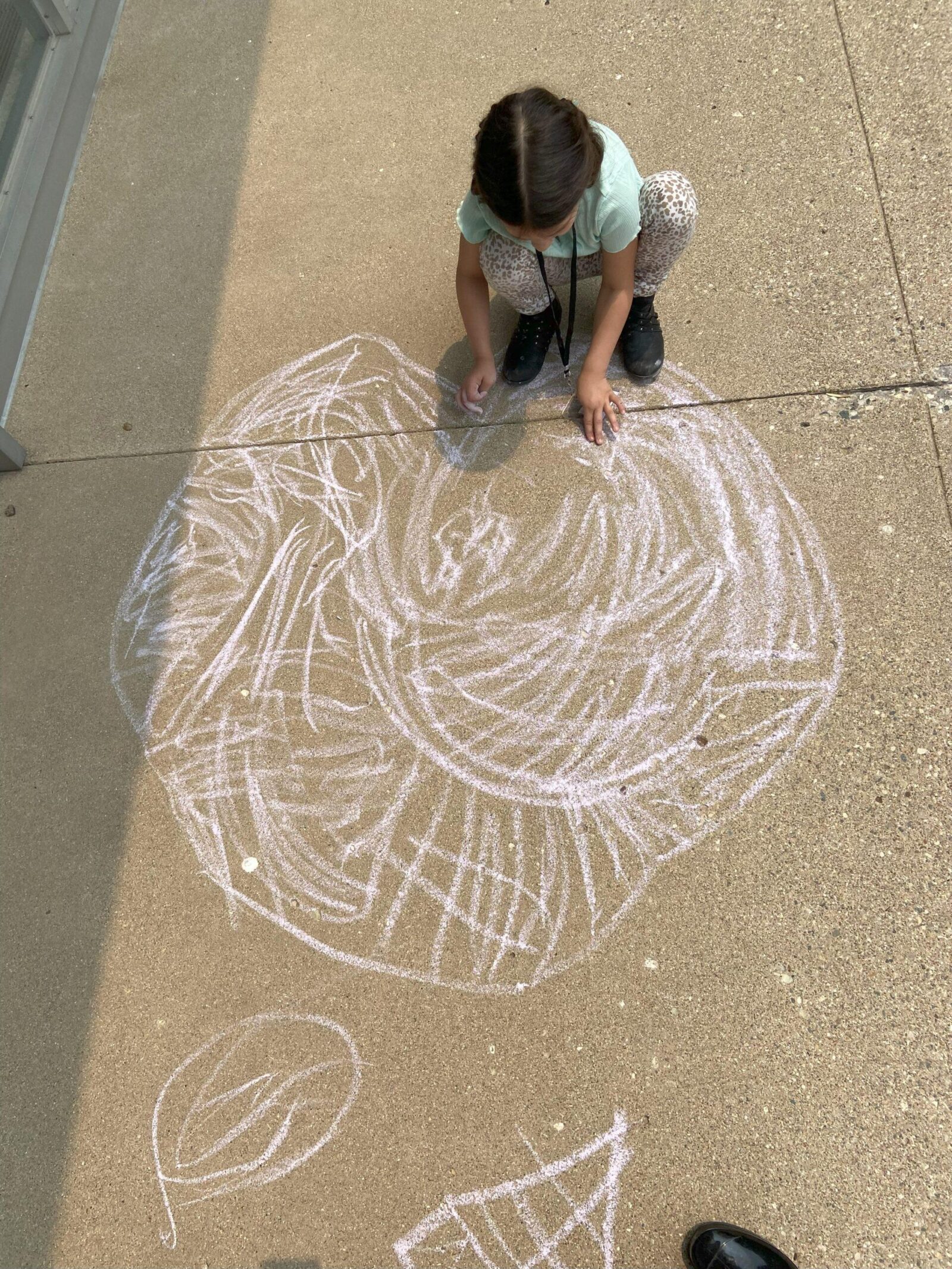 Student creating a sidewalk drawing