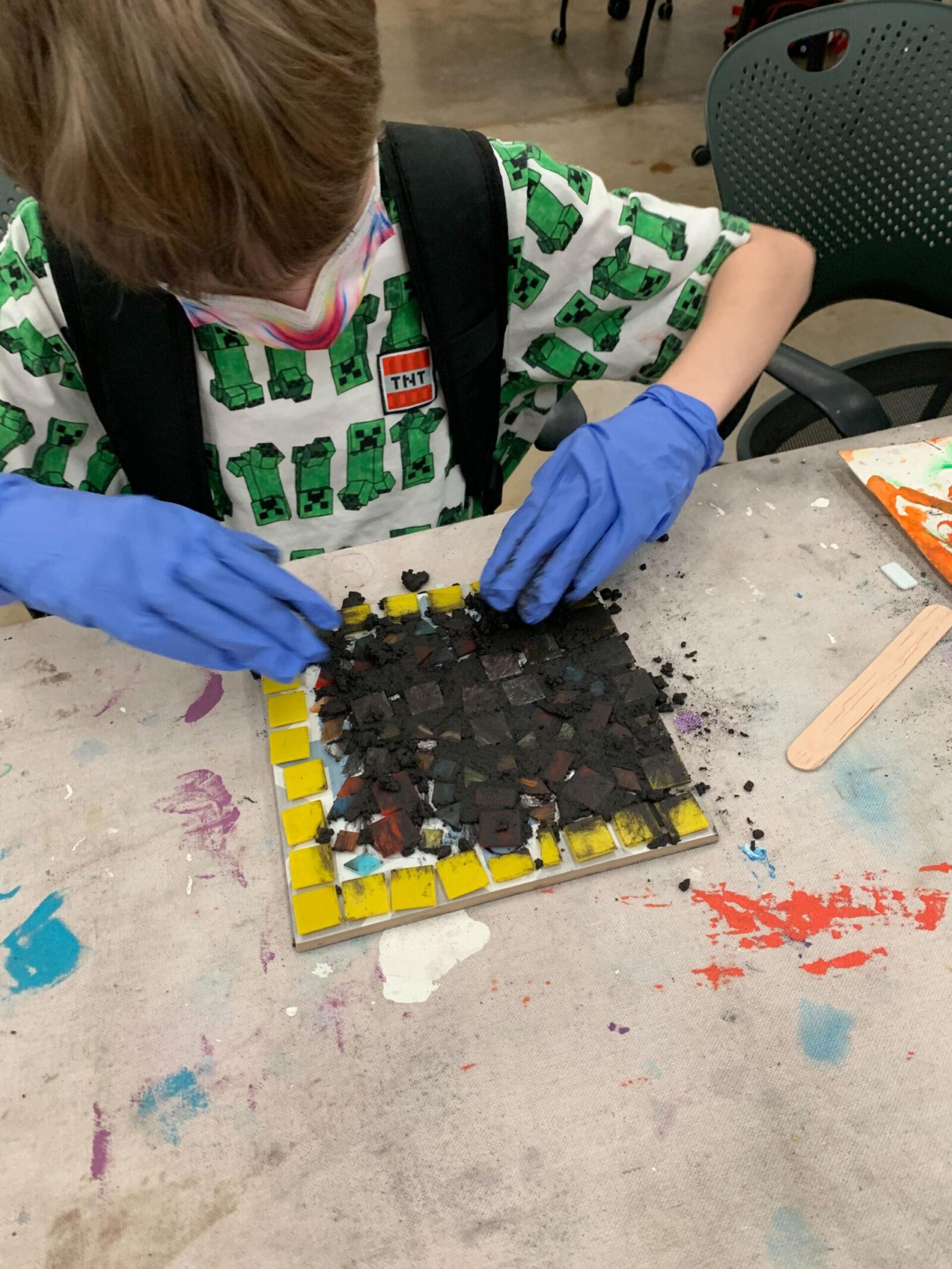 Student grouting their mosaic tile project