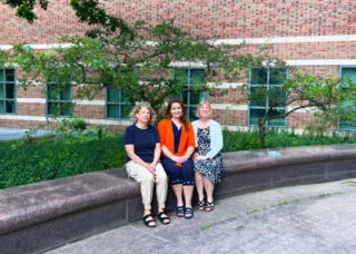 photo of Stephanie Ceman, Laura Hetrick, and Tracey Wszalek sitting outside Beckman