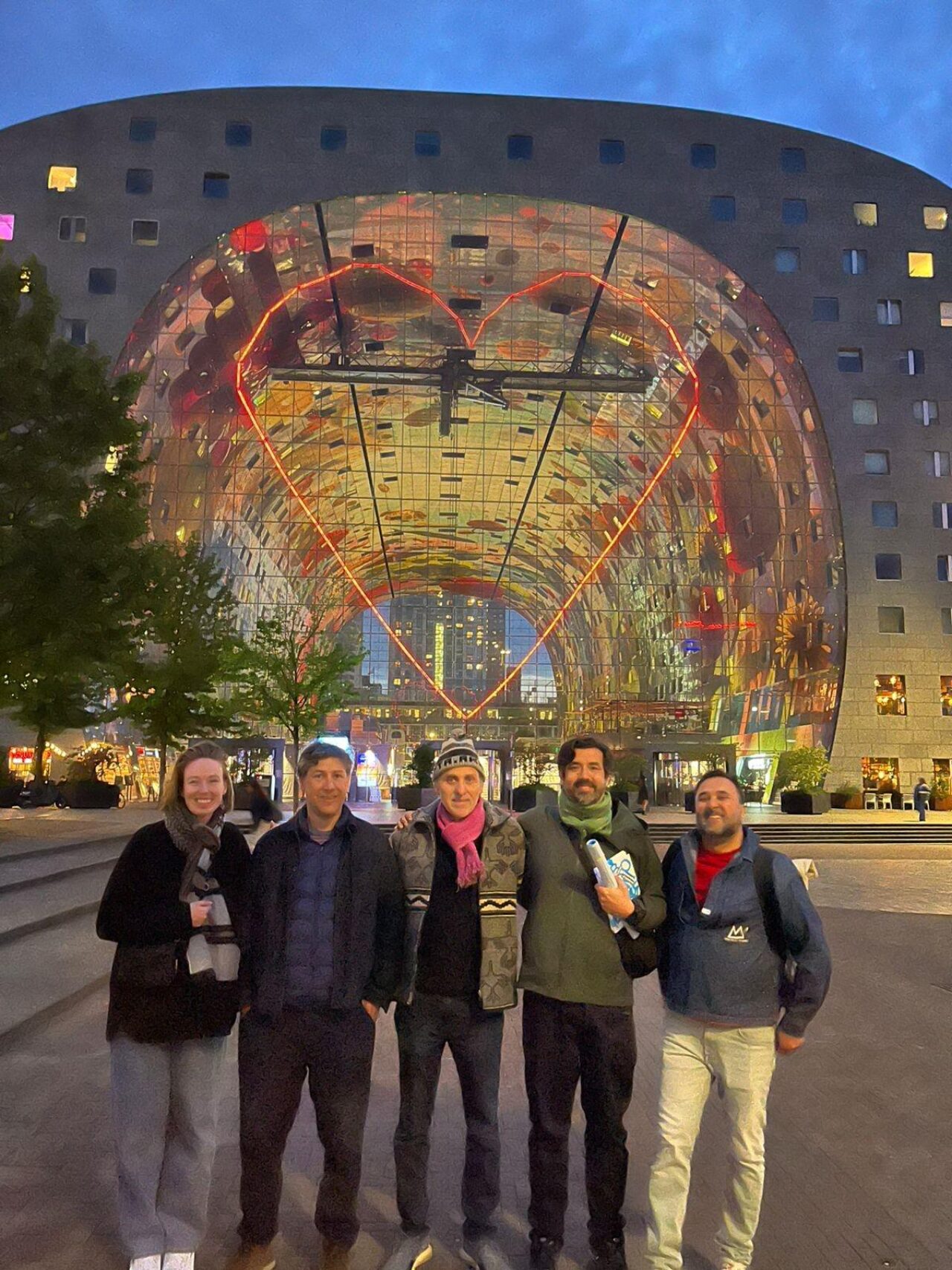 many people gathered outdoors by a large city tunnel