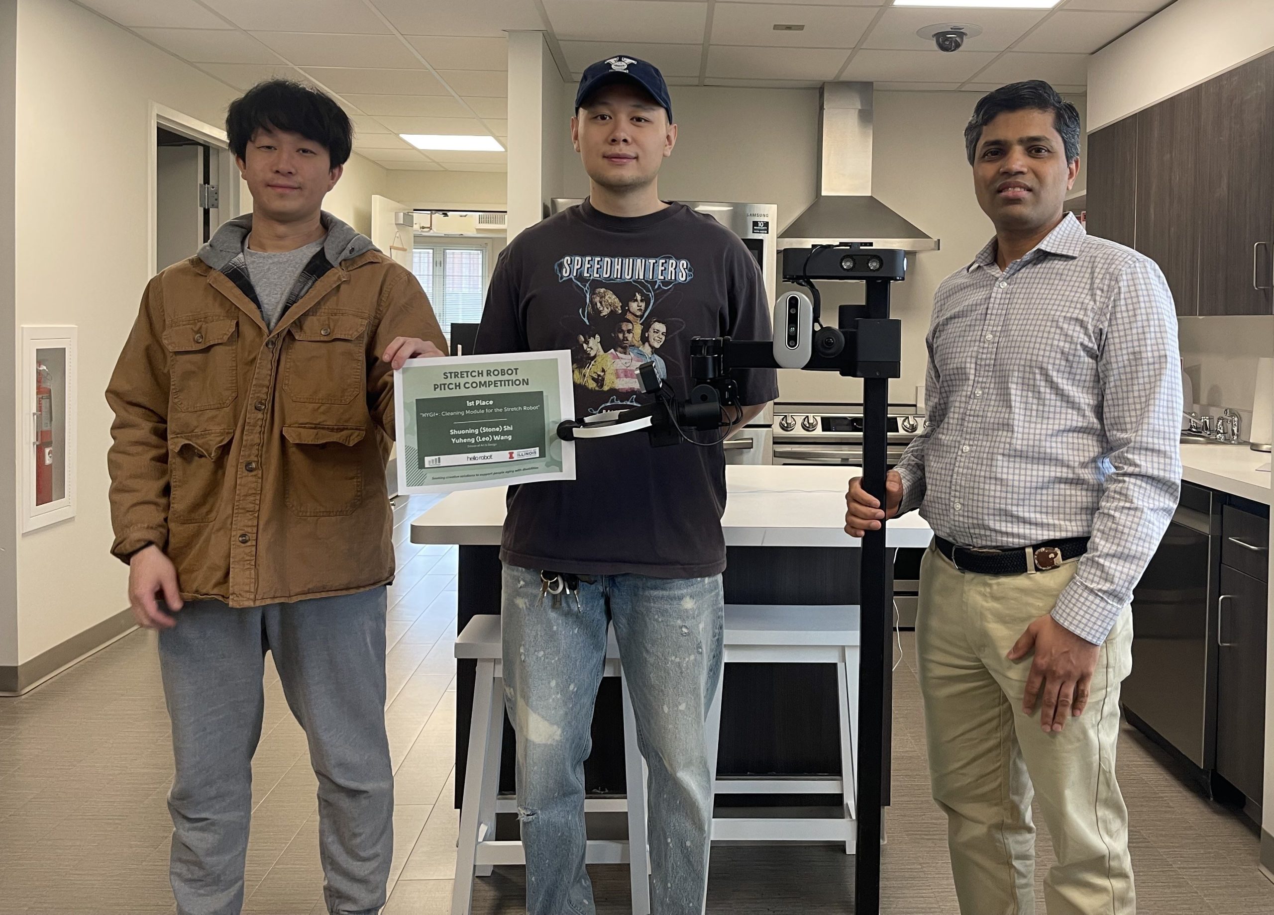 3 people standing in a lab, two hold a certificate