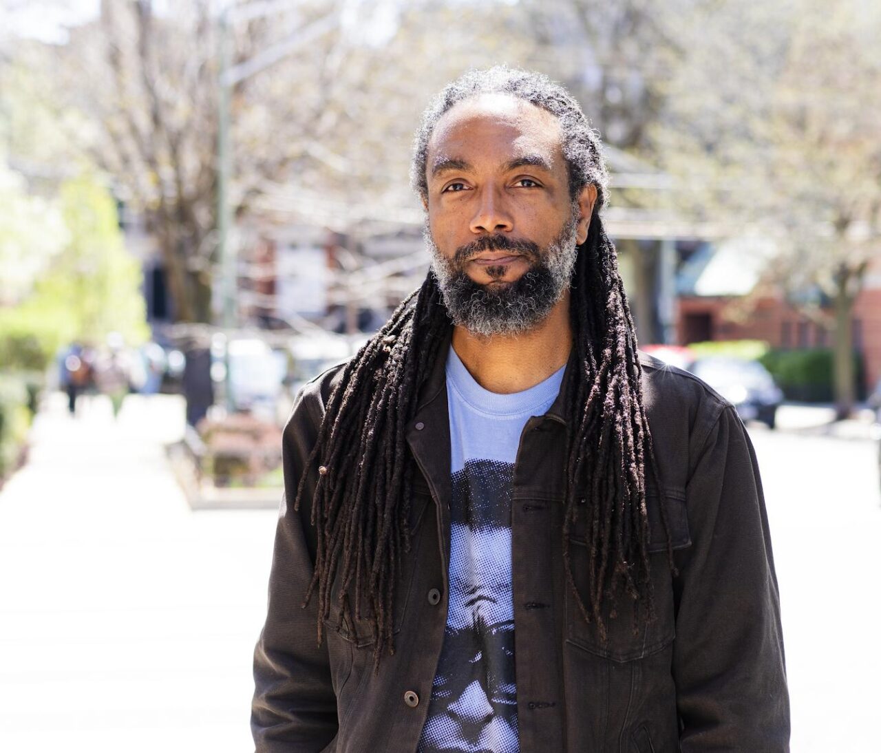 portrait of someone with facial hair and locks on sunny day outdoors