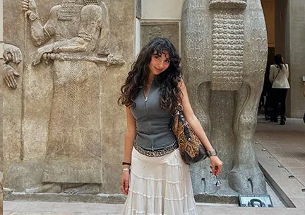 photograph of a student in front of ancient sculpture