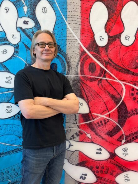 Ron Laboray in front of his work