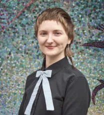 young person in front of tiled wall