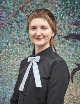 young person in front of tiled wall