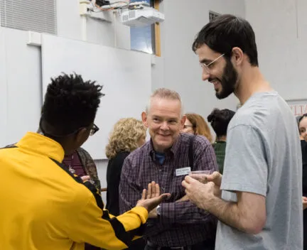 DPAC member, guest artist, and student smiling in conversation