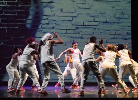 A group of dancers surround a soloist